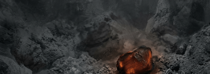 A glowing ember surrounded by gray ash and charred remains
